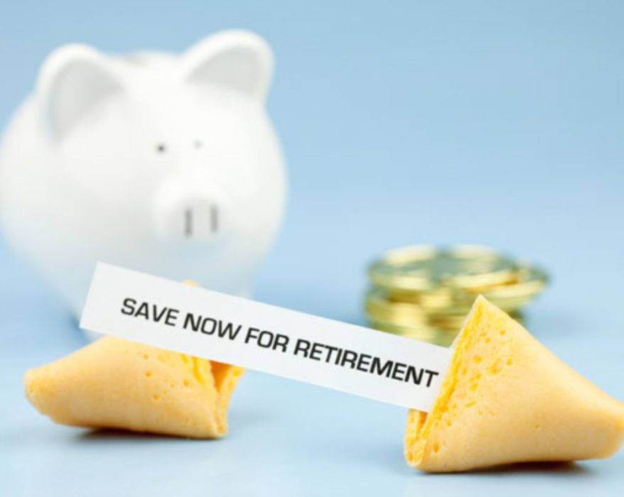 Fortune cookie with a message saying 'Save now for retirement,' placed near a piggy bank and stacked coins